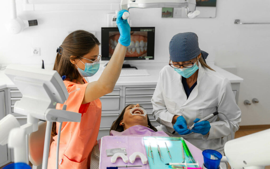 Dentists treating smiling patient in modern practice – Smilezone Zug, experienced dentists.