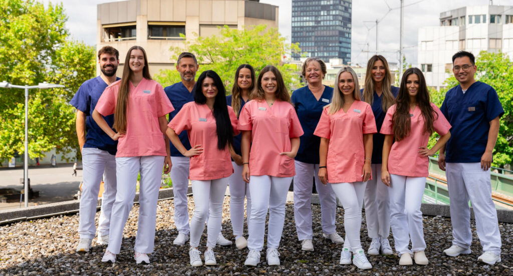 The friendly Smilezone dental team in Zug poses for a group picture.