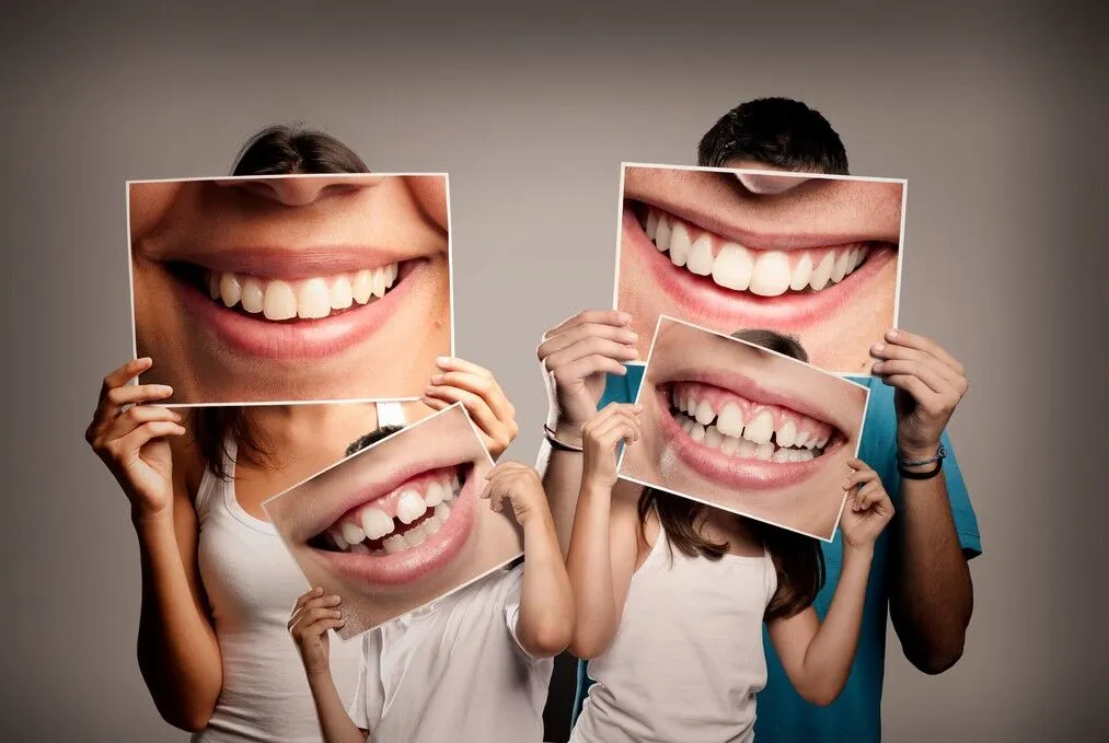 Family holding tooth pictures at Smilezone dental practice in Zug.