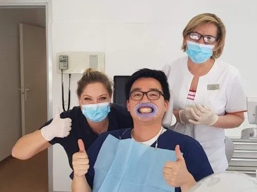 Friendly Smilezone team with a happy patient after successful teeth cleaning in Zug.