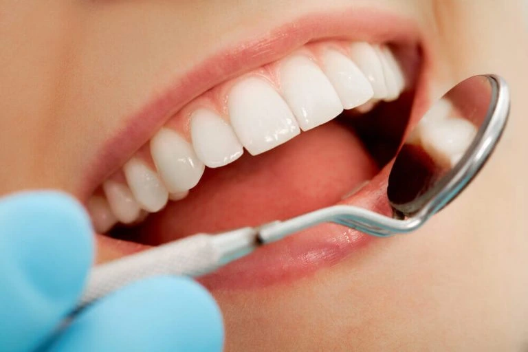 Zahnärztin untersucht Zähne einer Patientin – Smilezone Zug sorgt für gesundes, strahlendes Lächeln und professionelle Zahnreinigung.
