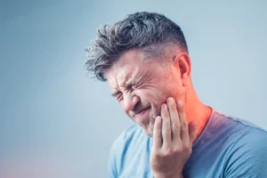 Mann mit starken Zahnschmerzen sucht Notfall Zahnarzt in Zug – Smilezone bietet schnelle Soforthilfe bei Zahnschmerzen
