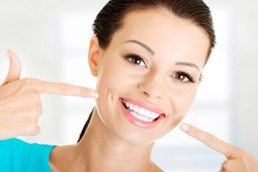 Woman highlights her brilliant smile after professional dental hygiene at Smilezone Zug.