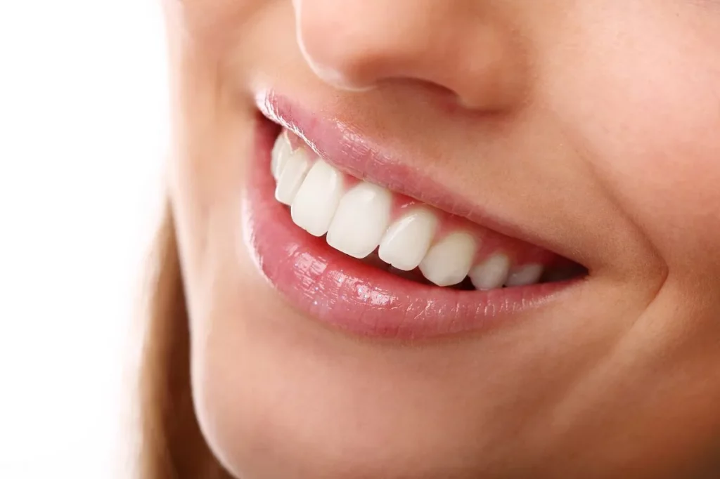 Smiling woman with healthy teeth after successful restoration at Smilezone Zug.