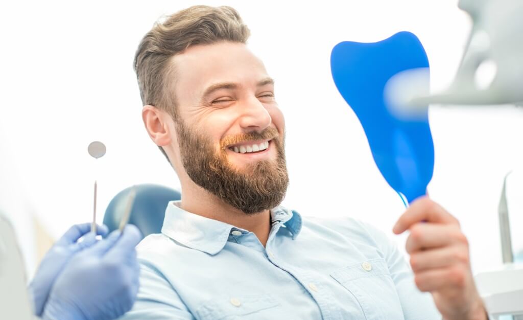 Lächelnder Mann nach erfolgreicher Weisheitszahn-OP – Smilezone Zug bietet sanfte Behandlung und schnelle Hilfe bei Zahnschmerzen